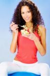 Women Seating On Blue Pilates Ball Holding Fresh Salad On Plate Stock Photo