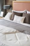 Wooden Bed With White And Brown Pillows In Bedroom Stock Photo