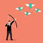 Businessman With A Bow And Arrow Hitting The Money Fly Stock Photo