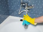 Woman Cleaning A Tap With A Rag Stock Photo