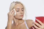 Young Woman Clean Face With Wet Wipes And Holding Mirror Stock Photo