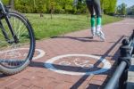 Girl Roller-skating And Bicycler On The Bike Path Stock Photo