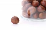 Single Roasted Chestnuts Outside Bottle On White Floor Stock Photo