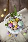 Easter Eggs In The White Basket On Rustic Wooden Background Stock Photo