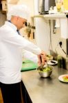 Male Chef Busy In Giving Final Touch To Recipe Stock Photo