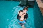 The Kid And Mom Play Together In The Pool Stock Photo