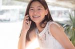 Portrait Of Thai Student Teen Beautiful Girl Using Her Phone And Smile Stock Photo