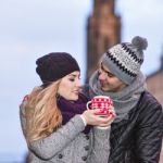 Young Couple In Love Embracing And Drinking Hot Drink From Red C Stock Photo