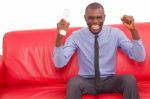 Man On The Sofa With Remote Control Rejoices Stock Photo