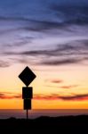 Road Sign Silhouette And Colorful Sunset Stock Photo