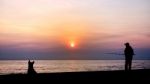 Silhouette Of Man Fishing Stock Photo