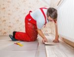 Young Handyman Installing Wooden Floor Stock Photo