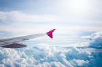 Cloudy Sky And Red Airplane Wing As Seen Through Window On Aircr Stock Photo