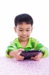 Little Asian (thai) Boy Using Digital Tablet At Desk Stock Photo