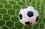 Soccer Football In Goal Net With Green Grass Field Stock Photo