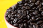 Coffee Bean In Coffee Cup With Yellow Background Stock Photo