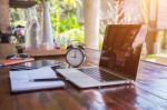 Desktop Mix Of Office Supplies And Gadgets . Desk With Laptop , Smart Phone, Glasses , Watch , Notebook , Tablet, On A Wood Table Stock Photo