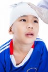 Asian Boy In Blue Sportswear With Trauma Of The Head. Doctor Makes A Bandage On Head Patient Stock Photo