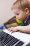 Small Boy Enjoys Playing Electric Piano Stock Photo