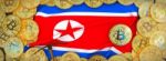 Bitcoins Gold Around North Korea  Flag And Pickaxe On The Left.3 Stock Photo