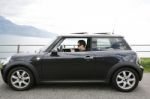 Young Man In His Fancy Car Chatting With His Device Up The Hills Stock Photo