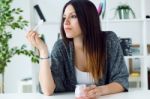 Beautiful Young Woman Eating Yogurt At Home Stock Photo