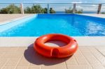 Orange Life Buoy At Blue Swimming Pool Stock Photo