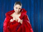 Beautiful Young Woman In Red Silk On Blue Background Stock Photo