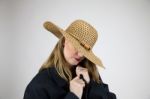 Blonde Female In Large Hat And Coat Hiding Face Stock Photo