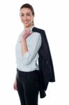 Businesswoman With Coat Slung Over Her Shoulder Stock Photo