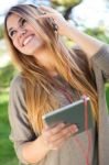 Portrait Of Beautiful Girl Listening To Music With Digital Table Stock Photo