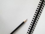 Black Pencil On Open White Paper Stock Photo