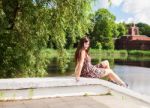 Beautiful Brunette Sitting Near The Lake Stock Photo