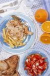 Turkey Steak With French Fries And Tomato Salad Stock Photo