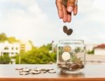 Close Up Of Glass Bottle Stacking Silver Coins Stock Photo