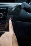 Closeup Of Young Woman Pressing Emergency Button On Car Sport Dashboard Stock Photo