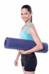 Female Trainer Holding Exercise Mat Stock Photo