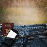 Blue Jeans With Cell Phone And Passport In A Pocket Background Stock Photo