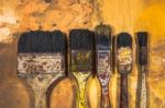 Oil Paint Brushes On Wood Painted Background Stock Photo