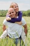 Man Piggybacking Her Girlfriend Stock Photo