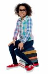 School Girl Sitting On Stack Of Books Stock Photo