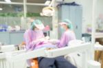 Dentist And Dental Assistants In Hospital ( Blurry Dental Background ) In Thailand Stock Photo