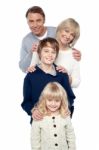 Family Of Four Posing In A Row Stock Photo