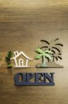 Wooden Sign Of House And Palm Tree With Open Sign Stock Photo