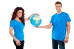 Smiling Young Couple Holding Globe Stock Photo