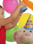 Girl Putting Hat On Teddy Stock Photo