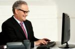 Cheerful Aged Man Working On Computer Stock Photo