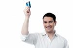 Smiling Man Holding Up His Credit Card Stock Photo