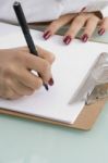 Female Writing On Clipboard Stock Photo