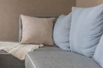 Brown And Blue Pillows With Blanket On Modern Grey Sofa Stock Photo